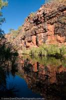 AUSTRALIA, Western Australia, West Kimberley. Sandstone cliffs line waterhole on Bachsten Creek.