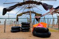 CAMBODIA, Siem Reap. Shade umbrellas rolled up at day's end, beach at Western Baray.