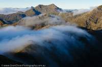 NEW ZEALAND, Fiordland National Park. Cascading cloud at dawn, Heath Mountains.