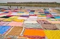 INDIA, Uttar Pradesh, Agra. Commercial clothes etc washing beside Yamuna River.