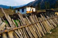 NEPAL, Karnali. Leaning paling fence and house.