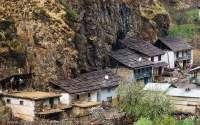NEPAL, Mugu. Traditional-style houses at base of cliff.