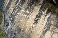 NEPAL, Mugu. Buddhist mantra engraved on water-stained rock face.