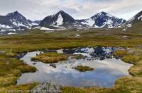 NORWAY, Troms, Lyngsalpan (Lyngen Alps). Peaks rise beyond Kalddalen valley, from Lomvatnan lakes.