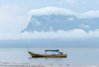 Fishing boat and Santubong Peninsula from Bako National Park, Sarawak, Malaysia.