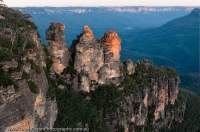 AUSTRALIA, New South Wales, Blue Mountains, Katoomba. Three Sisters, iconic view of sandstone pinnacles above Jamison valley,  from Echo Point, sunset.