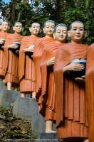 CAMBODIA, Kratie. Procession of concrete monks at Phnom Sombok pagoda.