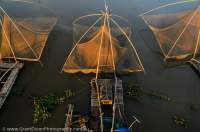 CAMBODIA, Kampong Cham. Fishing nets & house boats at Moat Khmong. Nets are lowered into river using bamboo frame attached to boats.