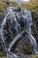 NEW ZEALAND, Fiordland National Park. Waterfall with quartz vein, Merrie Range.
