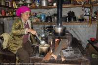 Woman in kitchen, with wood-fired stove, Manaslu Circuit, Gorkha, Nepal