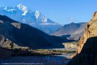 NEPAL. Fields and Tibetan-style houses on alluvial fan amidst braided channels of Kali Gandaki River, peak of Nilgiri (7061m) above, Mustang.