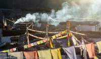 NEPAL. Buddhist (Tibetan) prayer flags and smoke from cooking fires, Mustang.