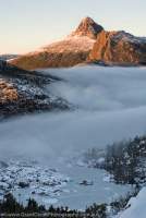 Peak of Mt Gould rises above mist and frozen lakes at dawn, Du Cane Range, winter. Cradle Mountain - Lake St Clair National Park, Tasmanian Wilderness World Heritage Area